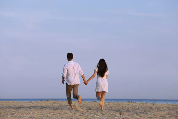 Pareja joven caminando en la playa — Foto de Stock