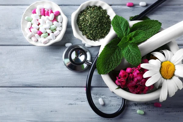 Medicina alternativa ervas e estetoscópio sobre fundo mesa de madeira — Fotografia de Stock