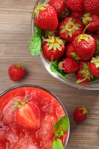 Glass of strawberry smoothie with berries on table close up — Stock Photo, Image