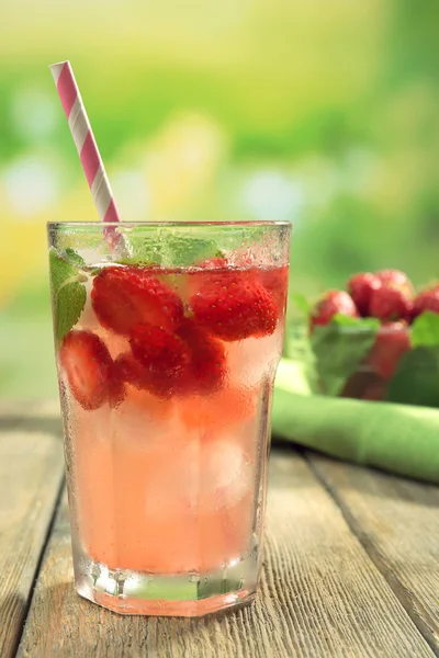 Склянка полуничного соку з ягодами на яскравому фоні — стокове фото