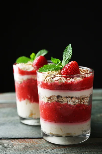 Postre con fresa fresca, crema y granola, sobre mesa de madera, sobre fondo oscuro —  Fotos de Stock