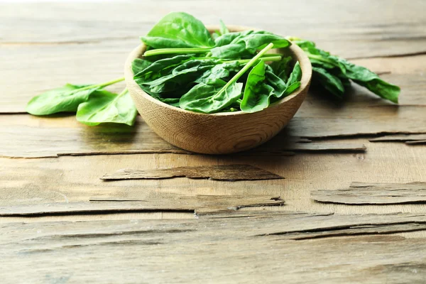 Ciotola di foglie di spinaci freschi su sfondo di legno — Foto Stock