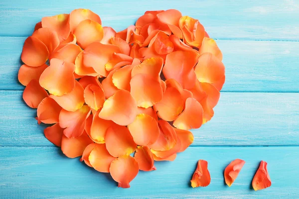 Schönes Herz aus Rosenblättern auf Holzgrund — Stockfoto