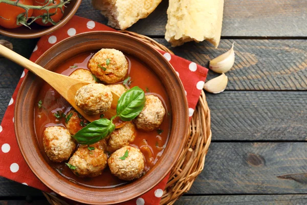 Meat balls with tomato sauce, wooden spoon on wooden background — Stock Photo, Image