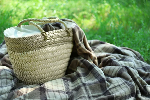 Keranjang Wicker dan Plaid untuk piknik di rumput hijau — Stok Foto