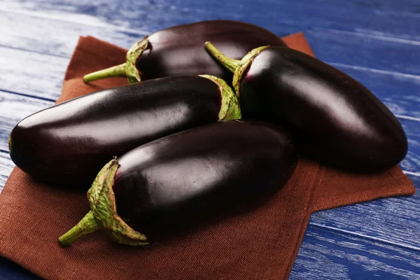 Färska aubergine på servett träbord — Stockfoto