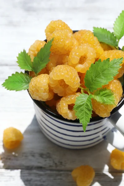 Cup of yellow raspberries on wooden table, closeup — Stock Photo, Image