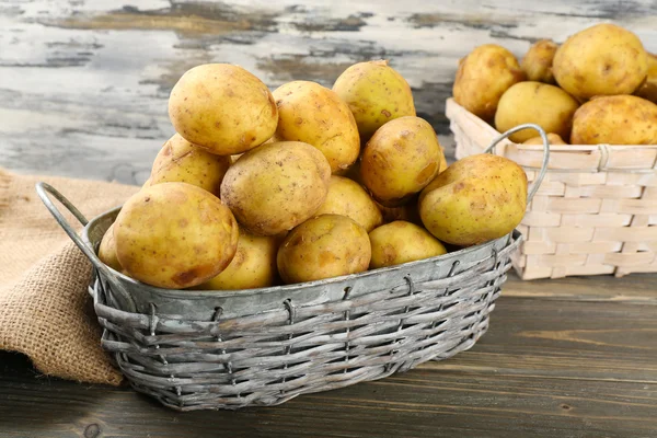 Ahşap masa hasır sepetleri genç patates yakın çekim — Stok fotoğraf