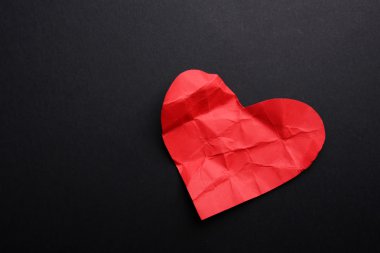 Buruşuk kağıt kalp siyah arka plan üzerine