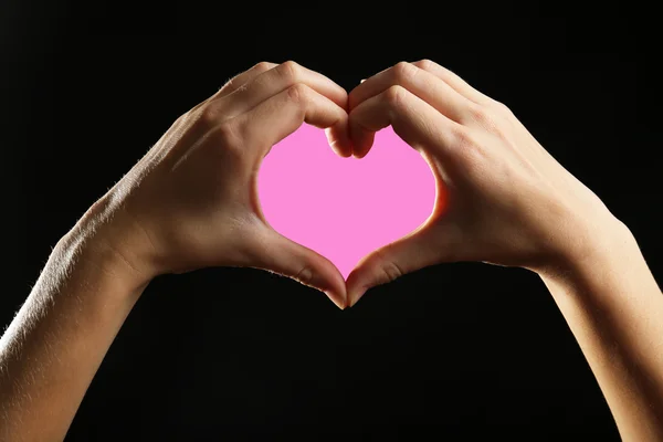 Human hands making heart on black background — Stock Photo, Image