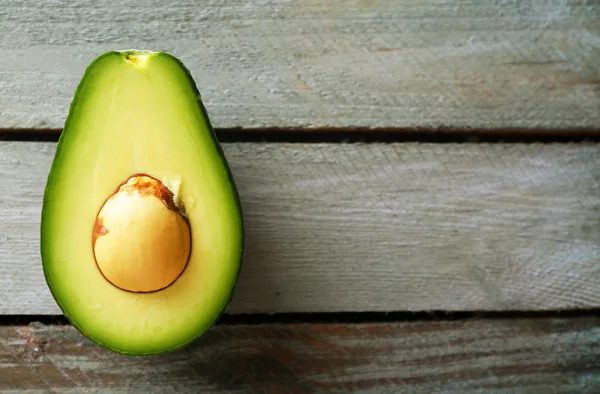 Sliced avocado on wooden background — Stock Photo, Image
