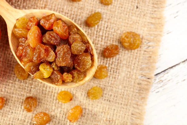 Raisins in wooden spoon with grapes on table close up — Stock Photo, Image