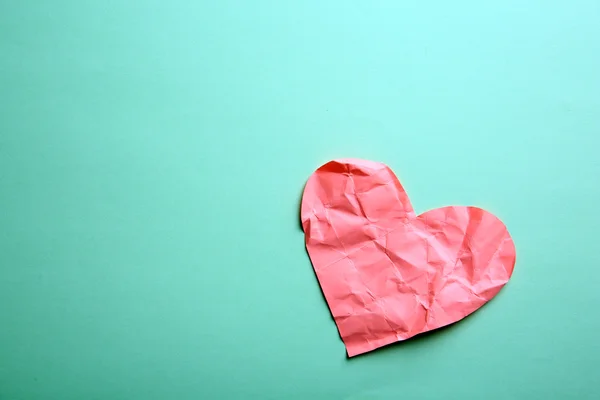 Crumpled paper heart on green background — Stock Photo, Image