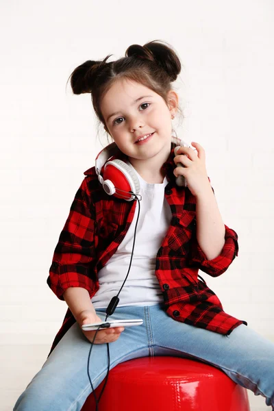 Menina bonita com fones de ouvido no quarto — Fotografia de Stock