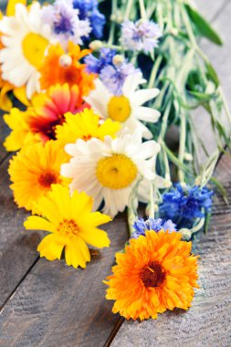 Ahşap masa üzerinde parlak kır çiçekleri