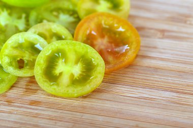 Ahşap zemin üzerine yeşil domates dilimleri