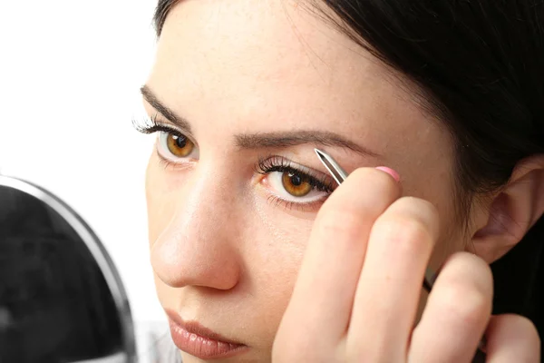 Mujer arrancando cejas con pinzas — Foto de Stock