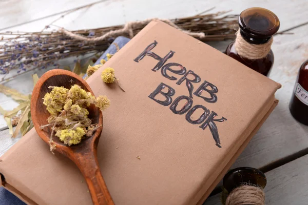 Gedroogde kruiden en boeken op tafel — Stockfoto