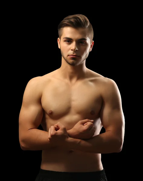 Muskulöser junger Mann mit dunklem Hintergrund — Stockfoto