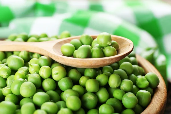 Fresh green peas in wooden bowl — Stock Photo, Image