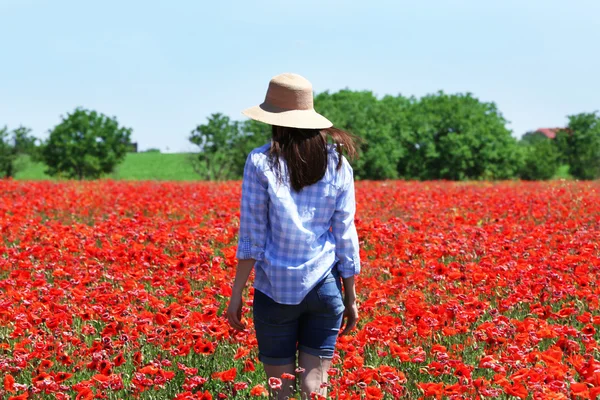 Nő séta a pipacs mező kék ég háttér — Stock Fotó