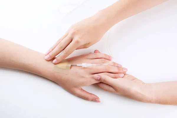 Ženské ruce pacienta ruku s kapátkem jehlou na posteli detail — Stock fotografie