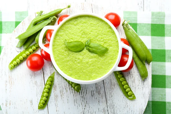 Tasty peas soup and cherry tomatoes on table close up — Stock Photo, Image