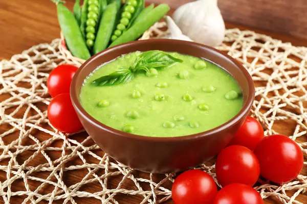 Tasty peas soup and vegetables on table close up — Stock Photo, Image