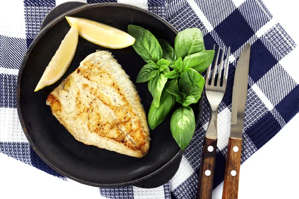 Assiette de filet de poisson avec basilic et citron sur la table close up — Photo