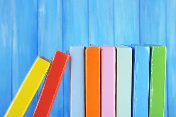 Colorful books on turquoise wooden background — Stock Photo, Image