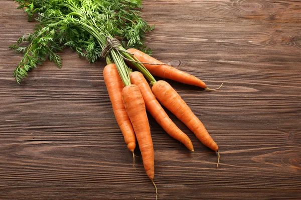 Fresh organic carrots on wooden background — Stock Photo, Image