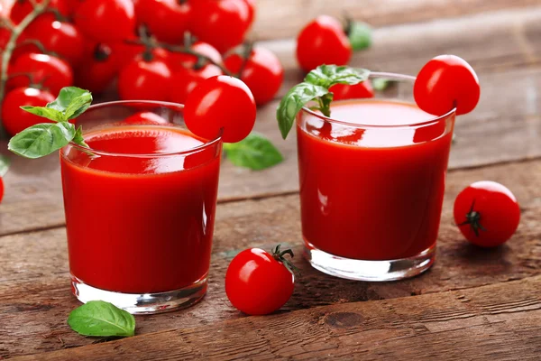 Szklanki soku pomidorowego na drewnianym stole, zbliżenie — Zdjęcie stockowe