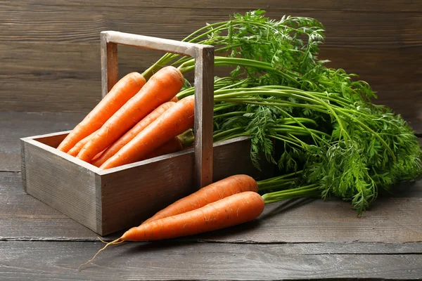 Свіжа органічна морква на ящику на дерев'яному фоні — стокове фото