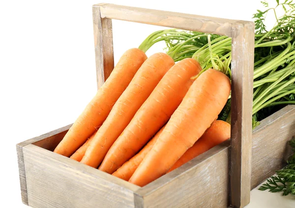 Молодая морковь в деревянной коробке, изолированной на белом — стоковое фото