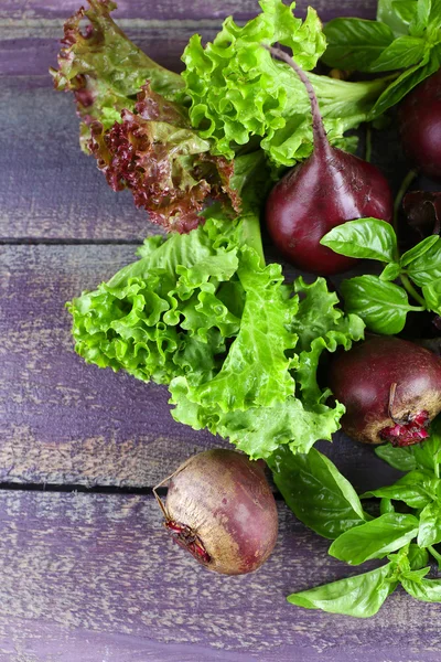 Red beets with greens on wooden table close up — Stock Photo, Image