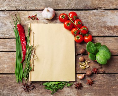 taze otlar, domates ve baharat ahşap arka plan üzerinde tarif kitabı açın