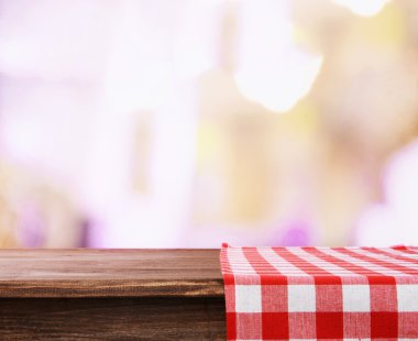 Empty wooden table with napkin on light background clipart