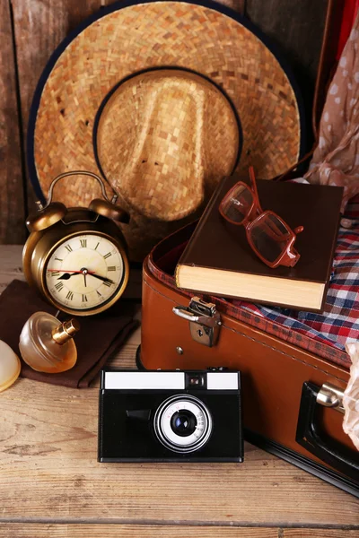 Packing suitcase for trip on wooden background — Stock Photo, Image