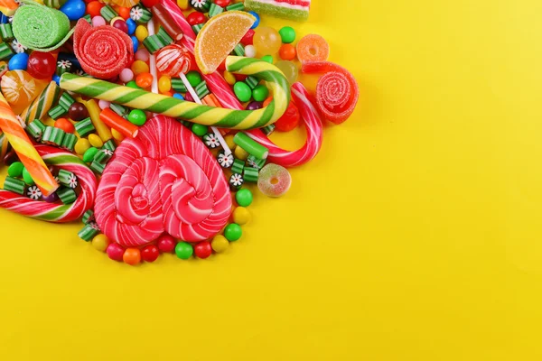 Bunte Bonbons auf gelbem Hintergrund — Stockfoto