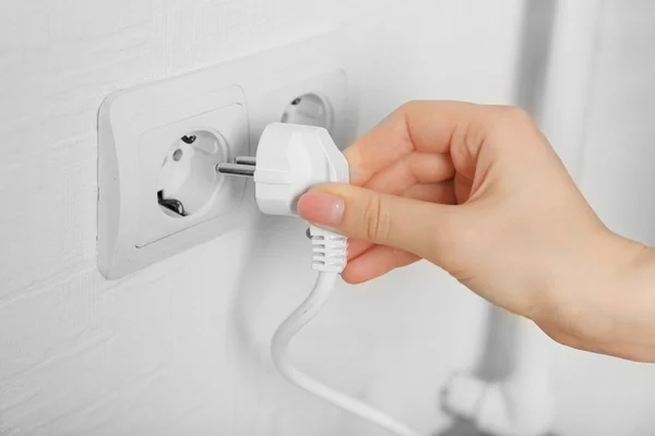 Mão colocando plug-in tomada de eletricidade de perto — Fotografia de Stock