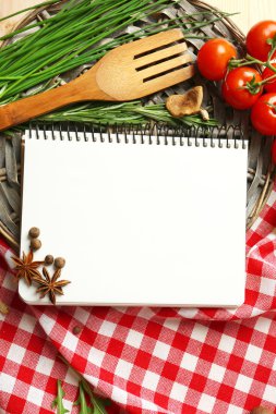 taze otlar, domates ve baharat ahşap arka plan üzerinde tarif kitabı açın