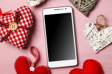 ahşap masa üzerinde yürekleri beyaz akıllı telefon.