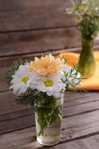 Hermosas flores en jarrones en la mesa de cerca — Foto de Stock