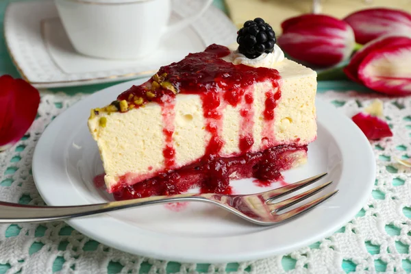 Tasty sepotong cheesecake dengan saus berry di atas piring di atas meja dekat — Stok Foto