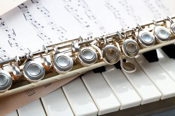 Flauta e piano com folha de música de perto — Fotografia de Stock