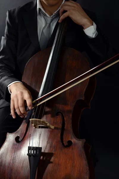 Homem tocando violoncelo no fundo escuro — Fotografia de Stock