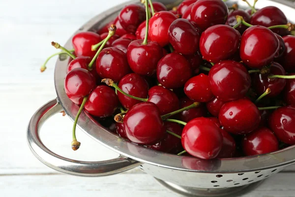 Cerezas dulces en colador en la mesa de cerca —  Fotos de Stock
