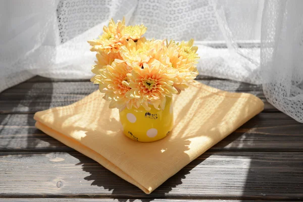 Beautiful chrysanthemums in pitcher on fabric background — Stock Photo, Image