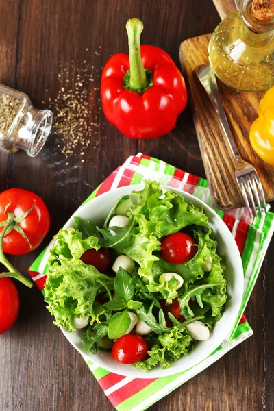 Färska grönsaker sallad i skål på bordet på nära håll — Stockfoto
