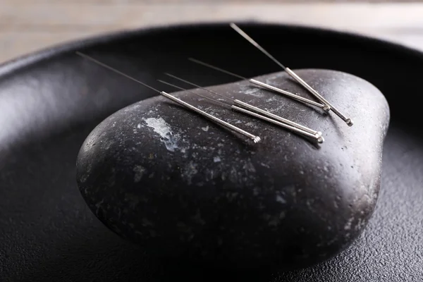 Agulhas de acupuntura com pedra spa na bandeja, close-up — Fotografia de Stock